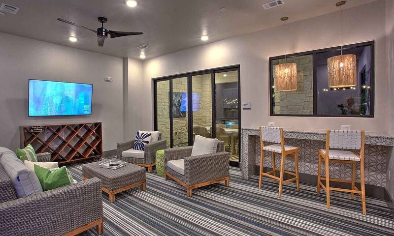 a living room with a table and chairs and a television at Hunters Creek Apartments, Texas, 76210