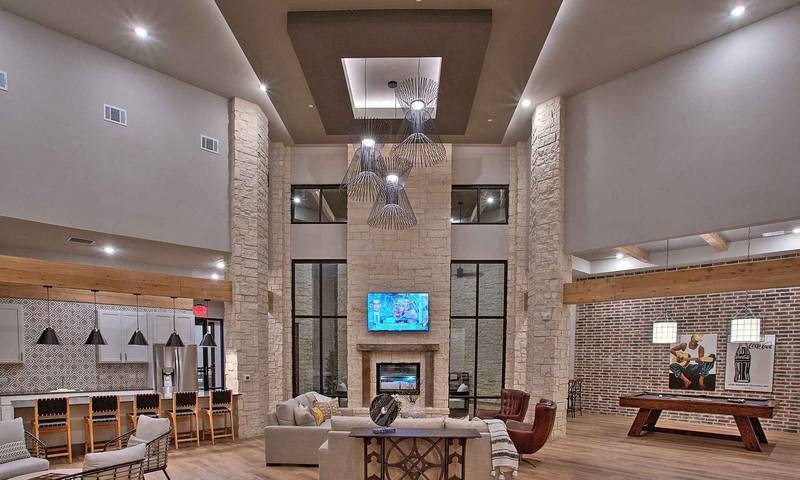 a lobby with a lot of furniture and a tv at Hunters Creek Apartments, Denton, TX 76210