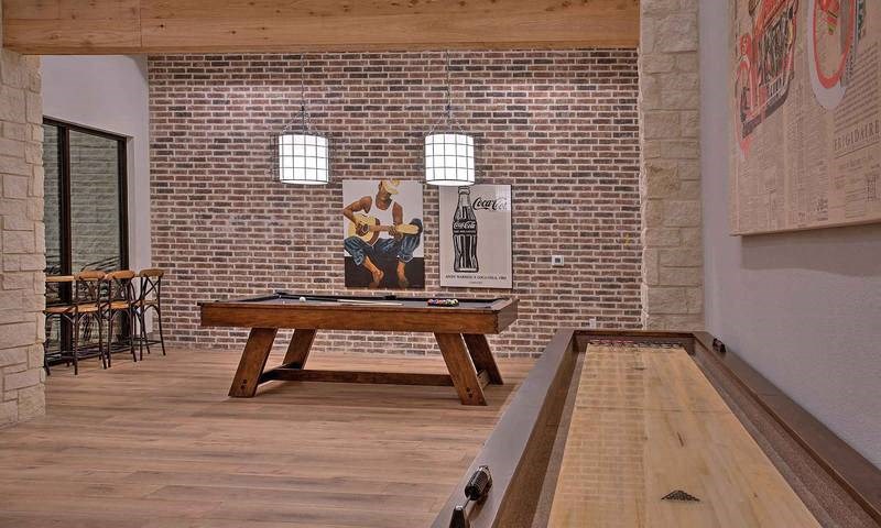 a pool table in a room with a brick wall at Hunters Creek Apartments, Texas, 76210