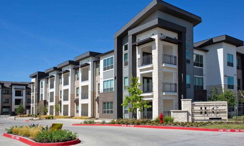 an apartment building with a red curb in front of it at Hunters Creek Apartments, Denton Texas