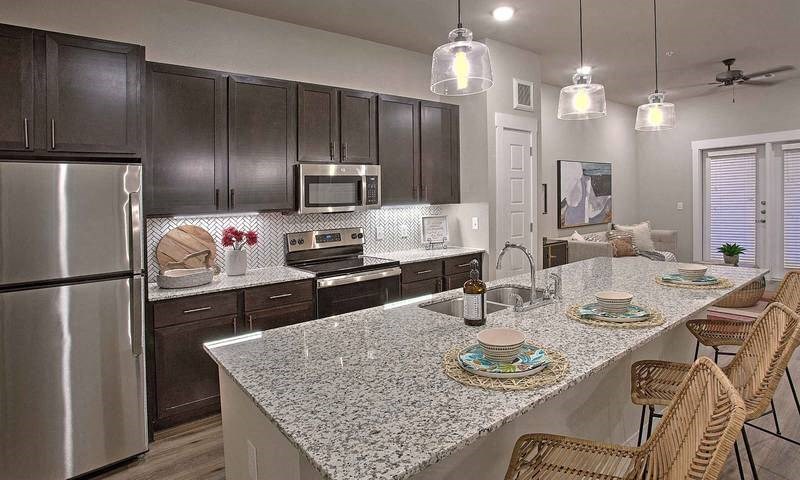 a kitchen with a counter and a table at Hunters Creek Apartments, Texas