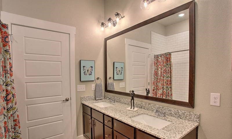 a bathroom with a sink and a mirror at Hunters Creek Apartments, Denton, TX 76210