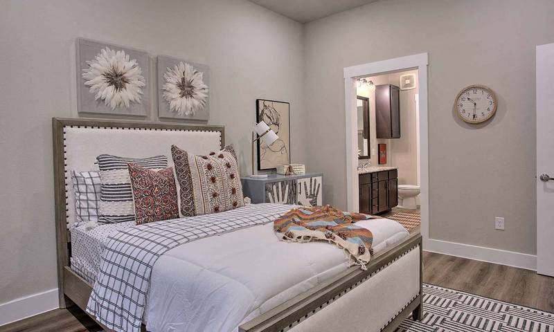 a bedroom with a bed and a clock on the wall at Hunters Creek Apartments, Denton, TX 76210