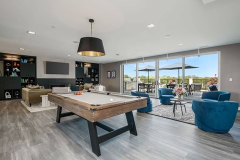 A room with a pool table and a view of the outside.