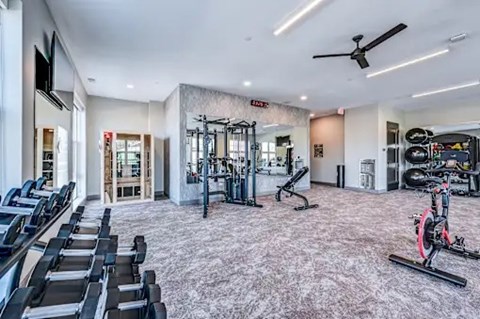 A spacious gym with a variety of equipment including treadmills, weights, and exercise bikes.