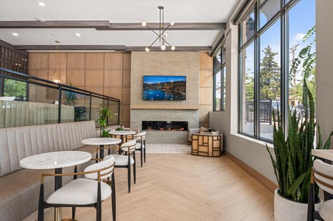 A modern dining area with a fireplace and a painting on the wall.