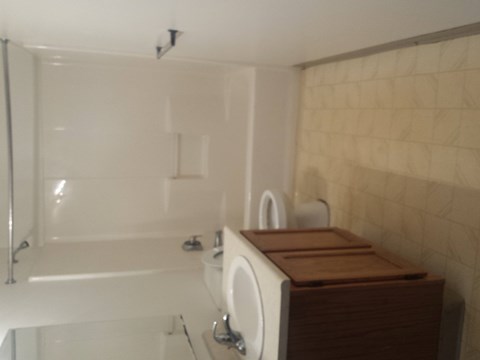 A white bathroom with a white tub and a white sink.