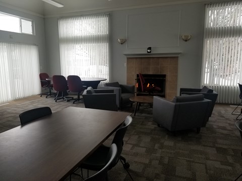 A conference room with a fireplace and chairs.