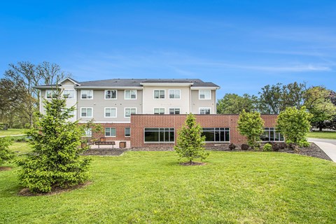 A large building with a grassy front yard.