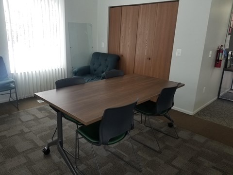 A conference room with a table, chairs, and a couch.