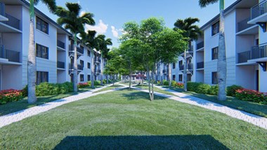 a grassy area with trees in front of an apartment complex