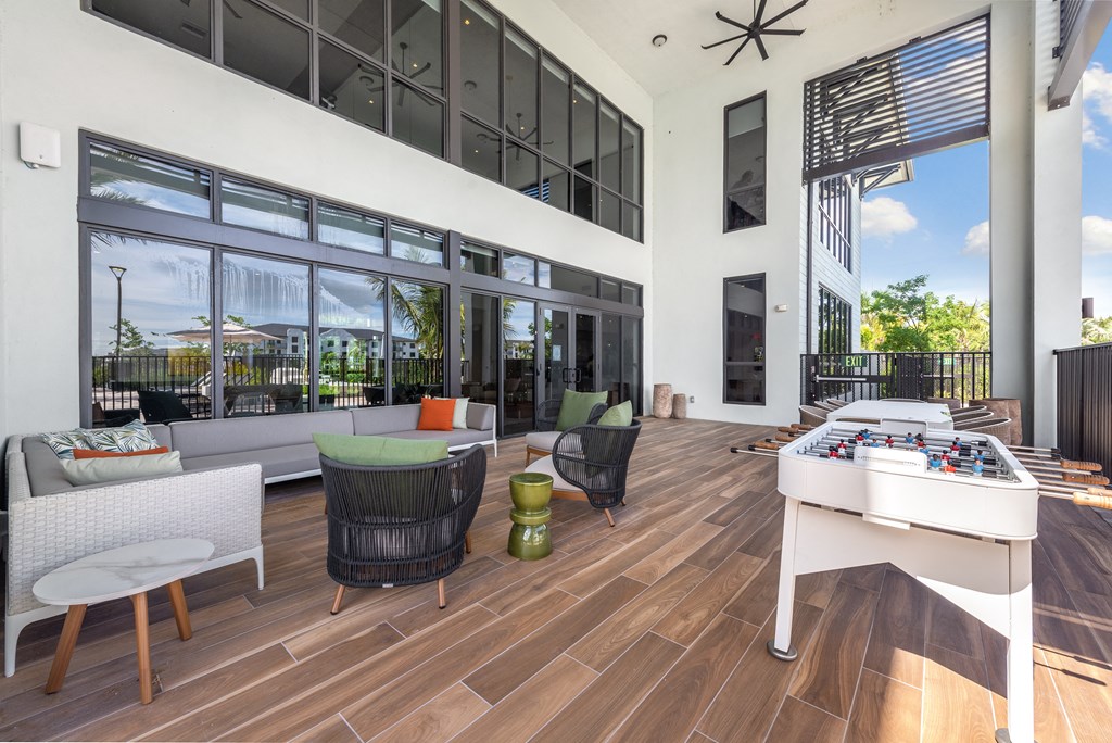 a patio with a foosball table and chairs