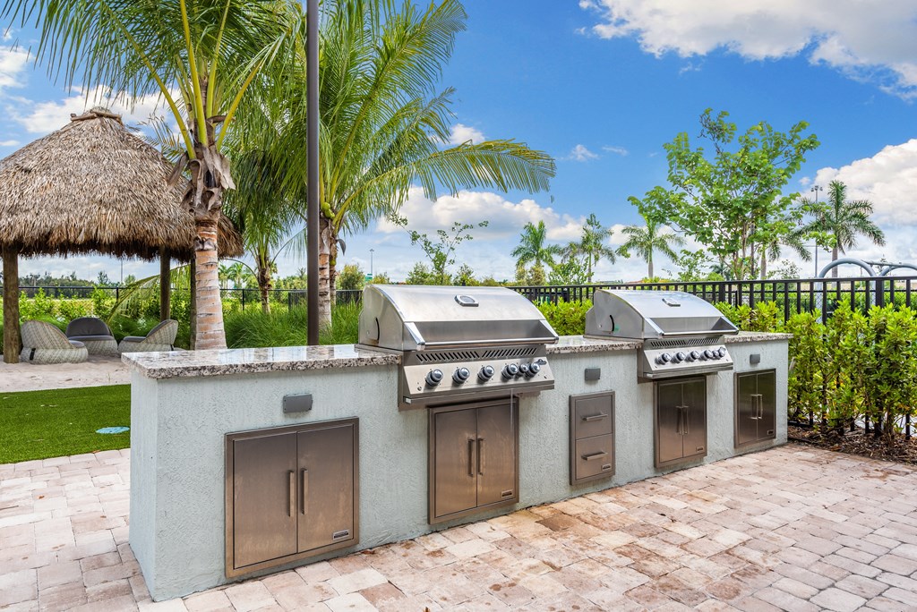 an outdoor kitchen with two bbq grills