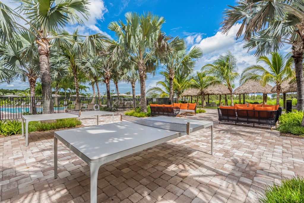 a patio with a ping pong table and benches