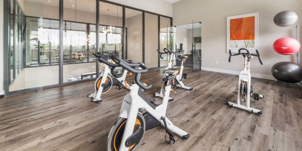 a group of exercise bikes sitting on top of a wooden floor