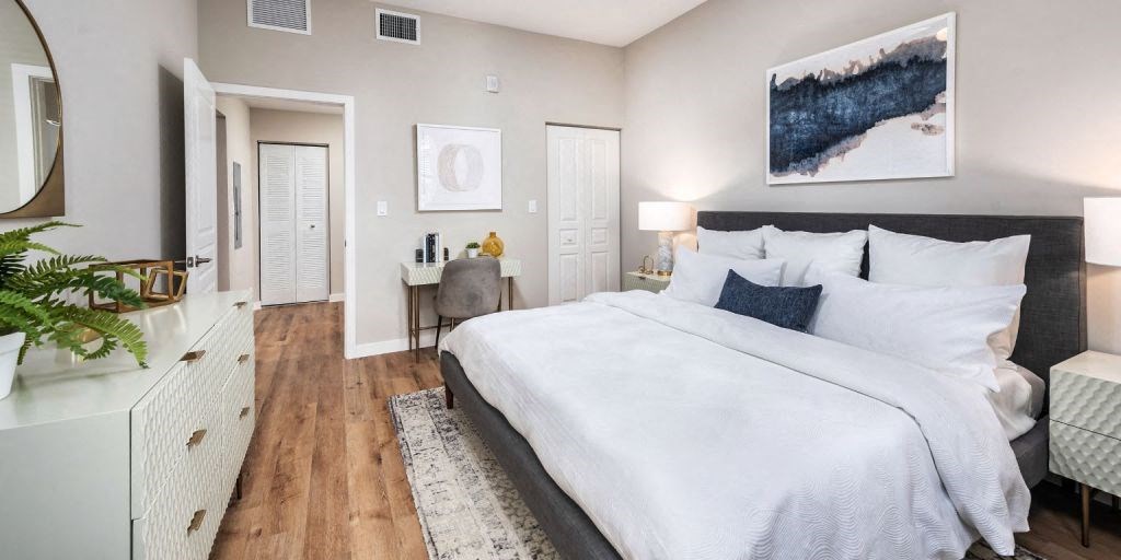 a bedroom with a large bed and a desk with a chair