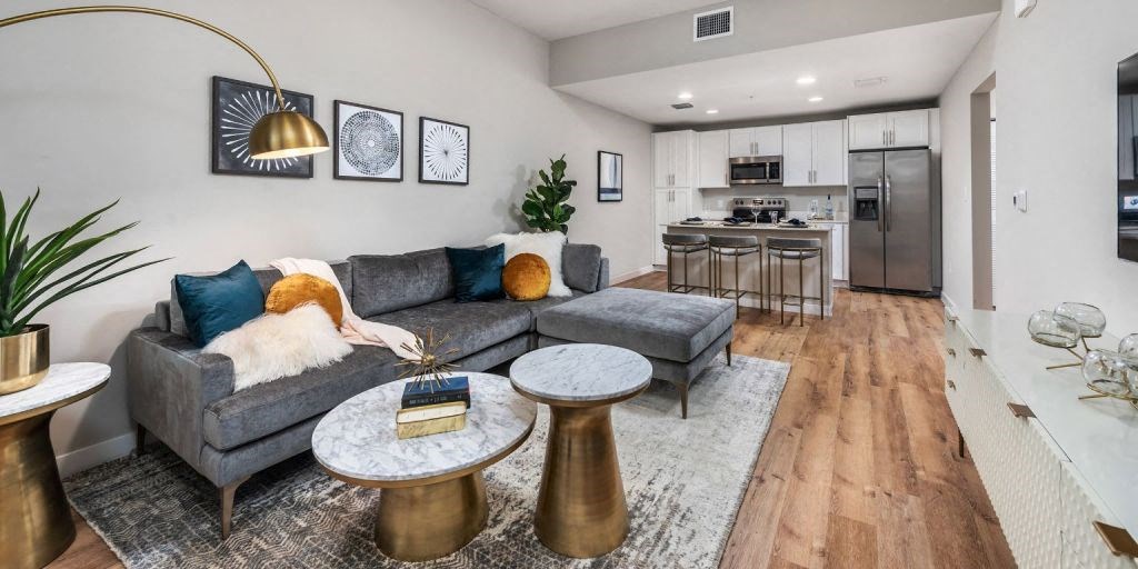 a living room with a couch a table and a kitchen in the background