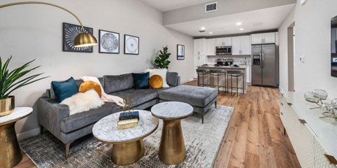 a living room and kitchen with a couch and tables