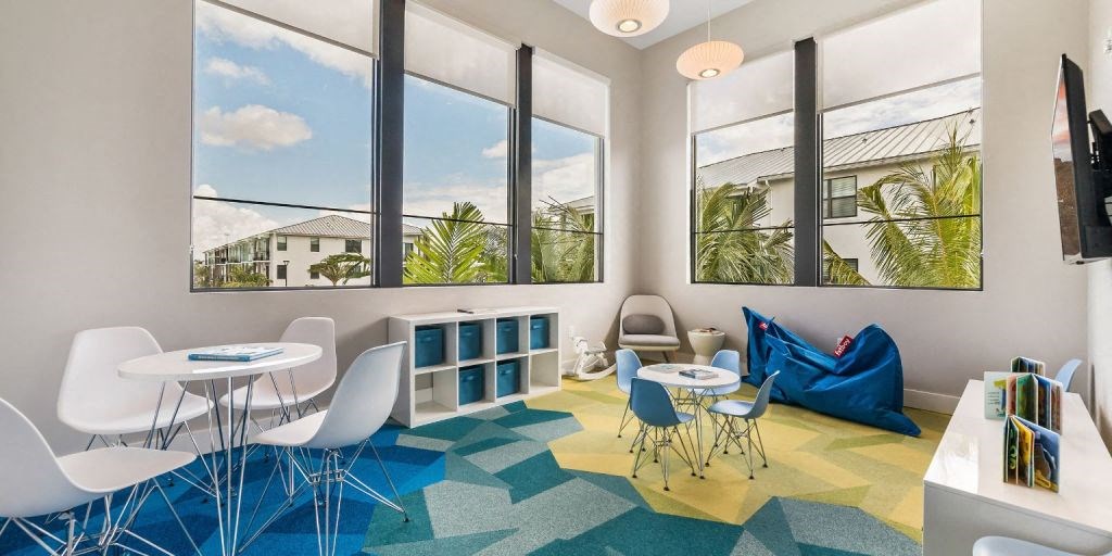 a room with a blue bean bag chair and white tables and chairs