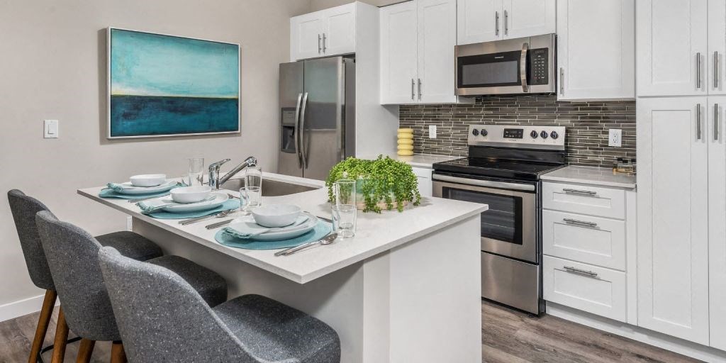a kitchen with white cabinets and stainless steel appliances