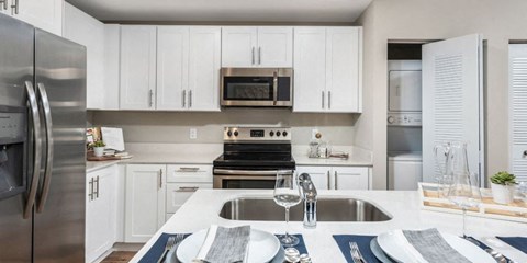 a kitchen with white cabinets and stainless steel appliances