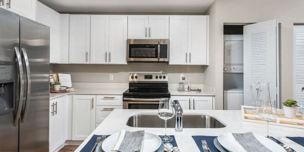 a kitchen with white cabinets and stainless steel appliances