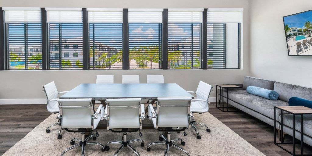 a conference room with a table and chairs and a couch in the background
