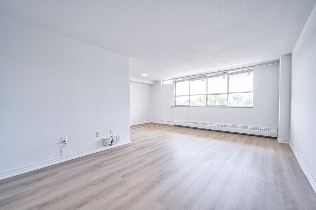 an empty living room with white walls and wooden floors