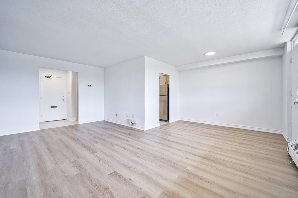 an empty living room with white walls and wood flooring