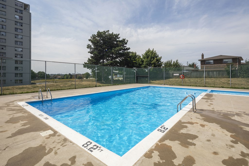 a swimming pool at a condominium with a fence around it