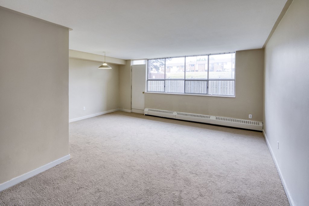 the living room of an empty apartment with a large window