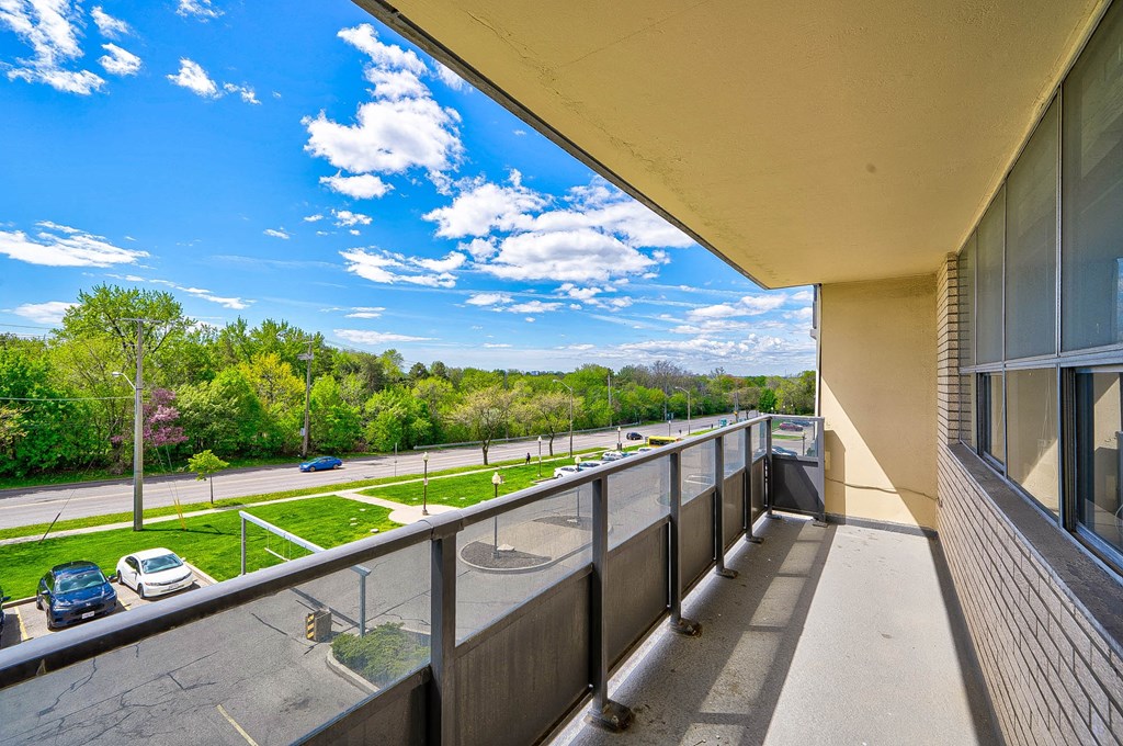 a balcony with a view of a parking lot and a blue sky