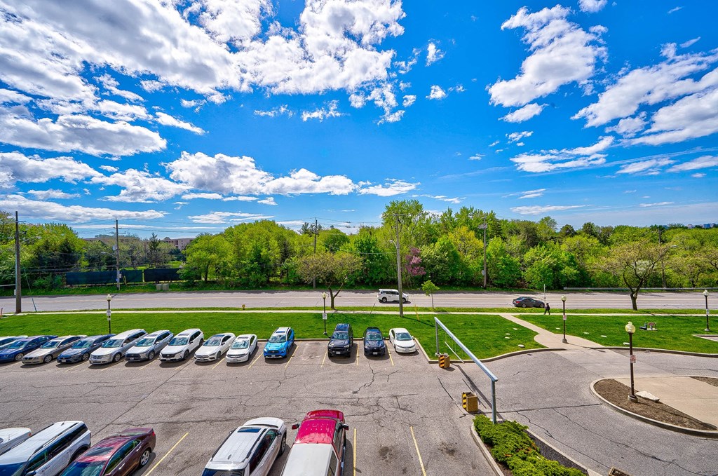 an aerial view of a parking lot with cars and trees