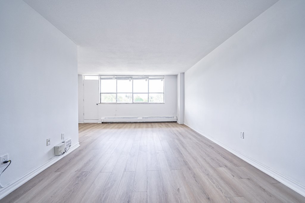an empty room with white walls and wooden floors