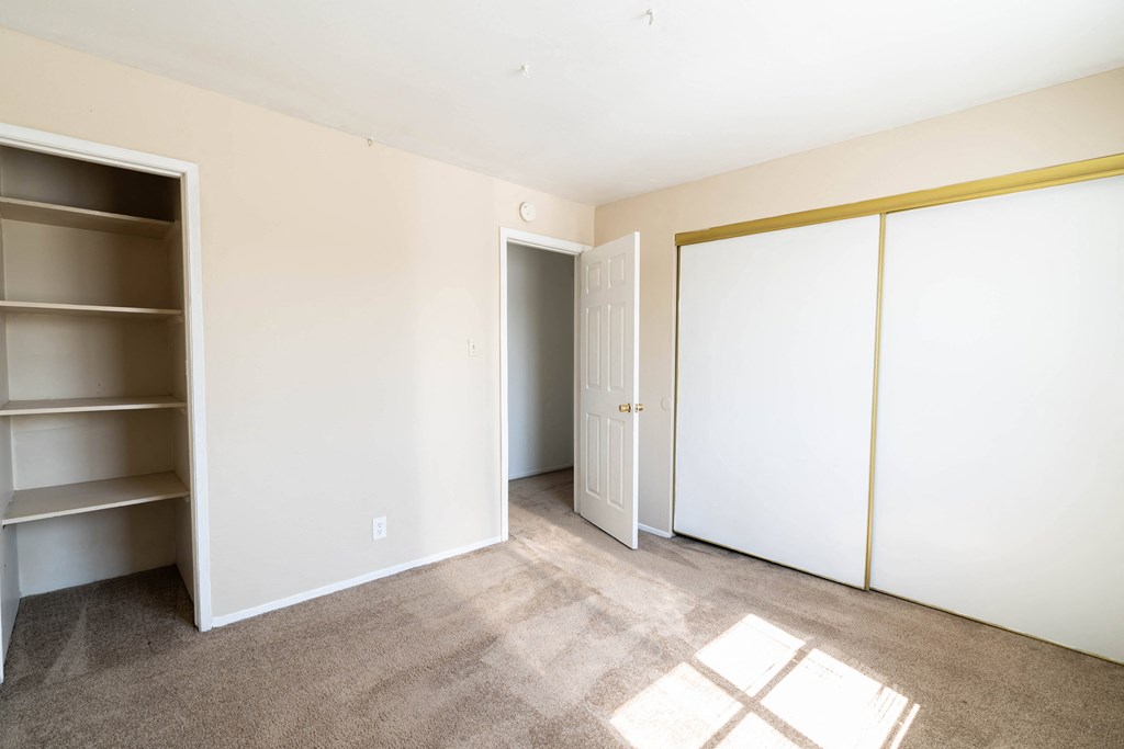 a bedroom with white walls and carpet