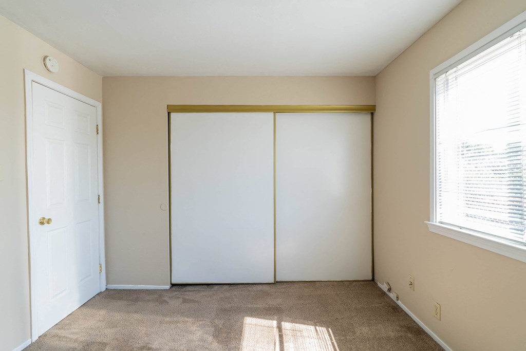 a bedroom with a closet and a window