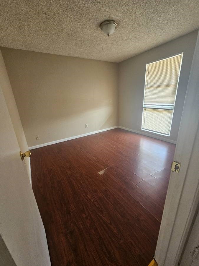 an empty room with a wooden floor and a window
