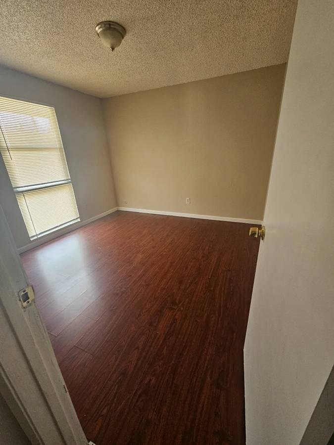 an empty room with a wooden floor and a window