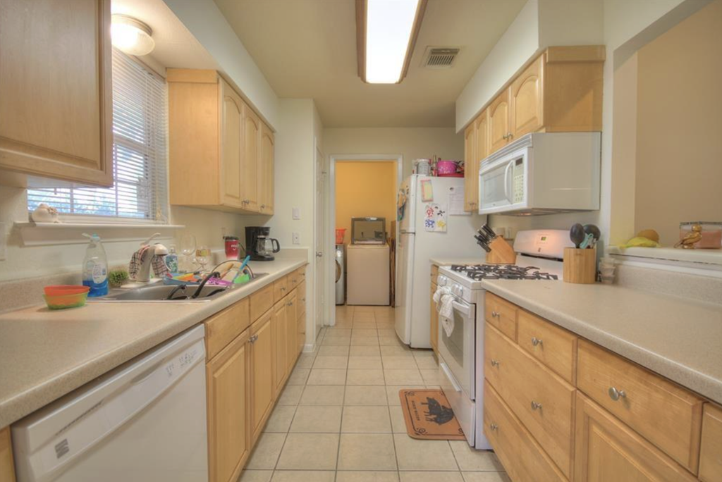 a kitchen with wooden cabinets and white appliances