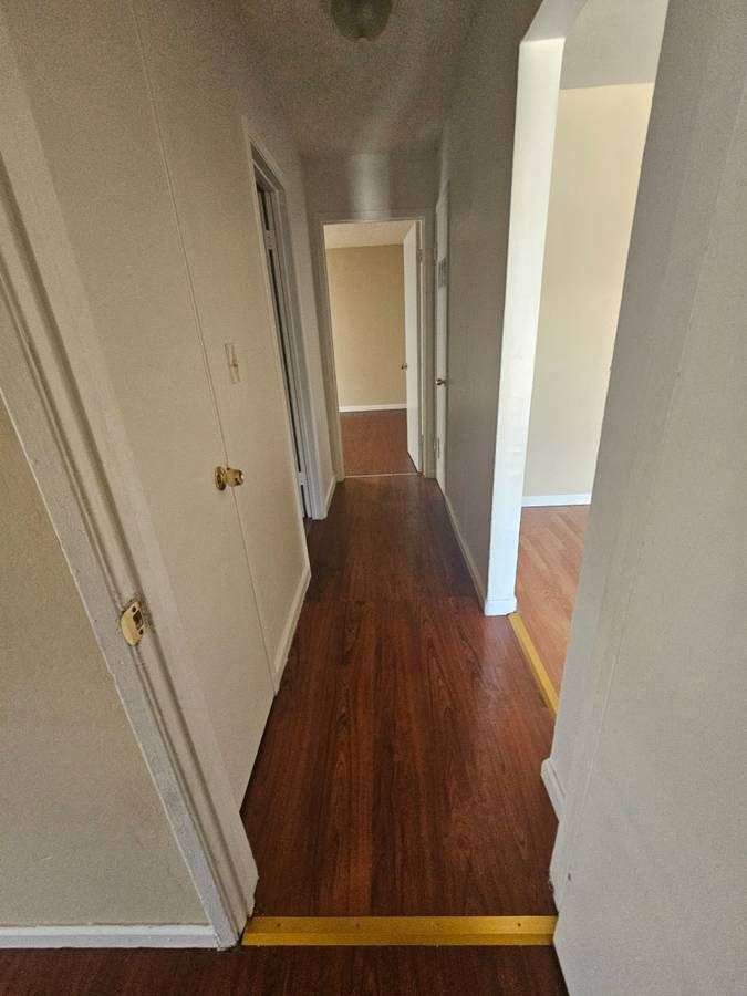 a hallway with a wooden floor and white walls