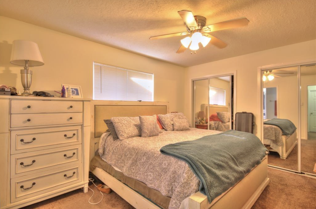a bedroom with a bed and a ceiling fan