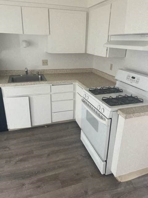 a white kitchen with a stove and a sink