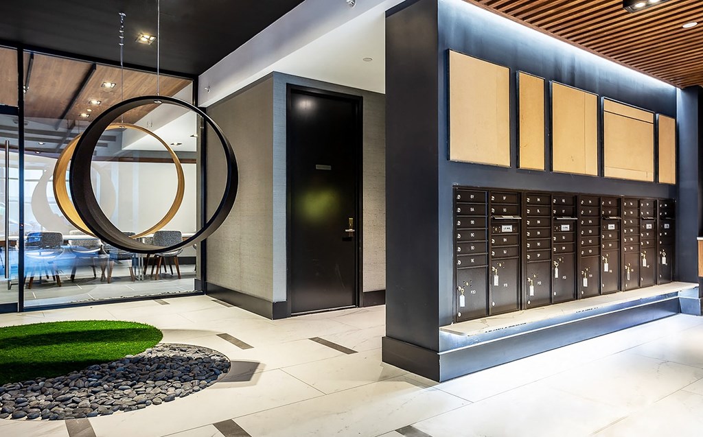 A modern lobby with a black and gold circular light fixture.