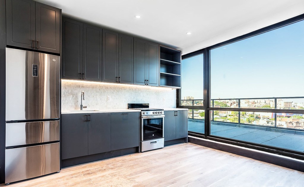 A modern kitchen with dark wood cabinets and stainless steel appliances.