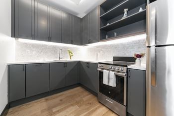 A modern kitchen with a stainless steel refrigerator and a black oven.