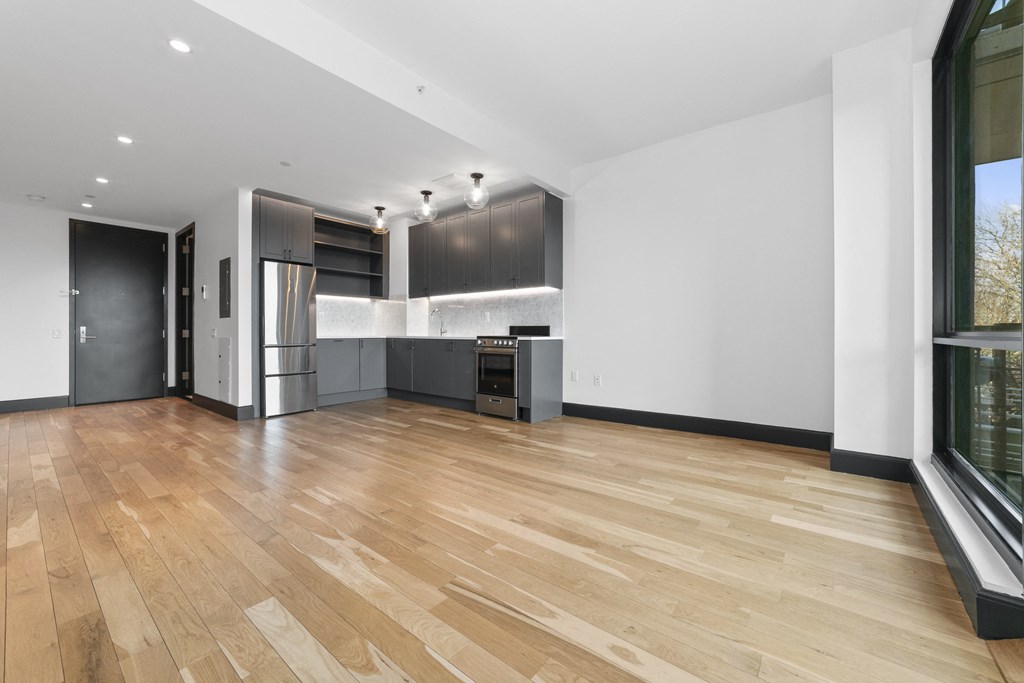 A kitchen with a refrigerator, oven, and sink.