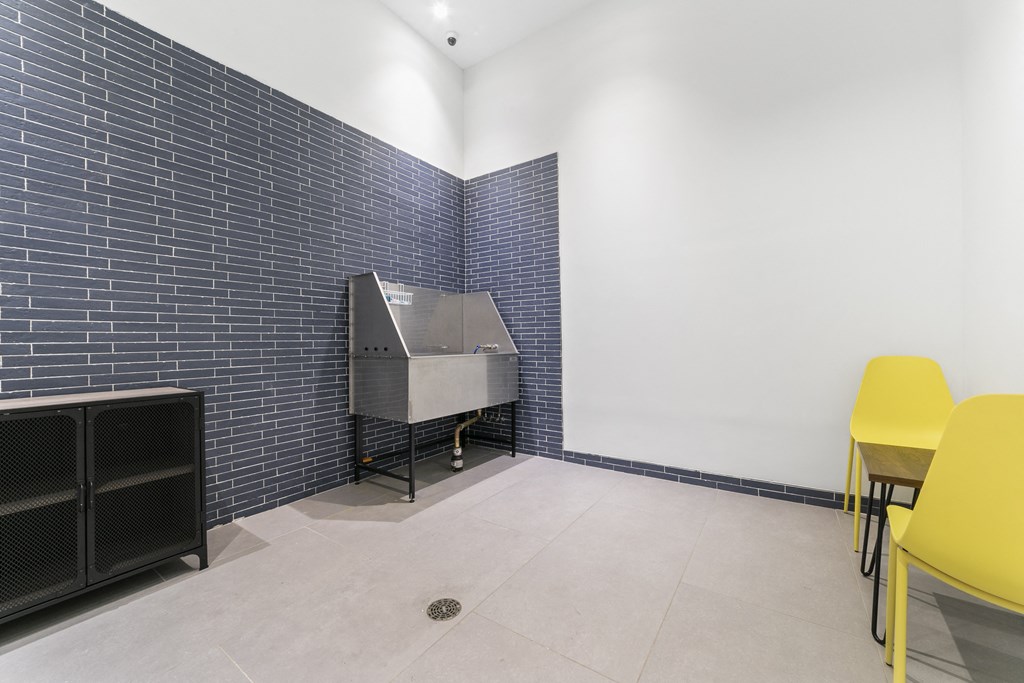 A room with a blue brick wall and a yellow chair.