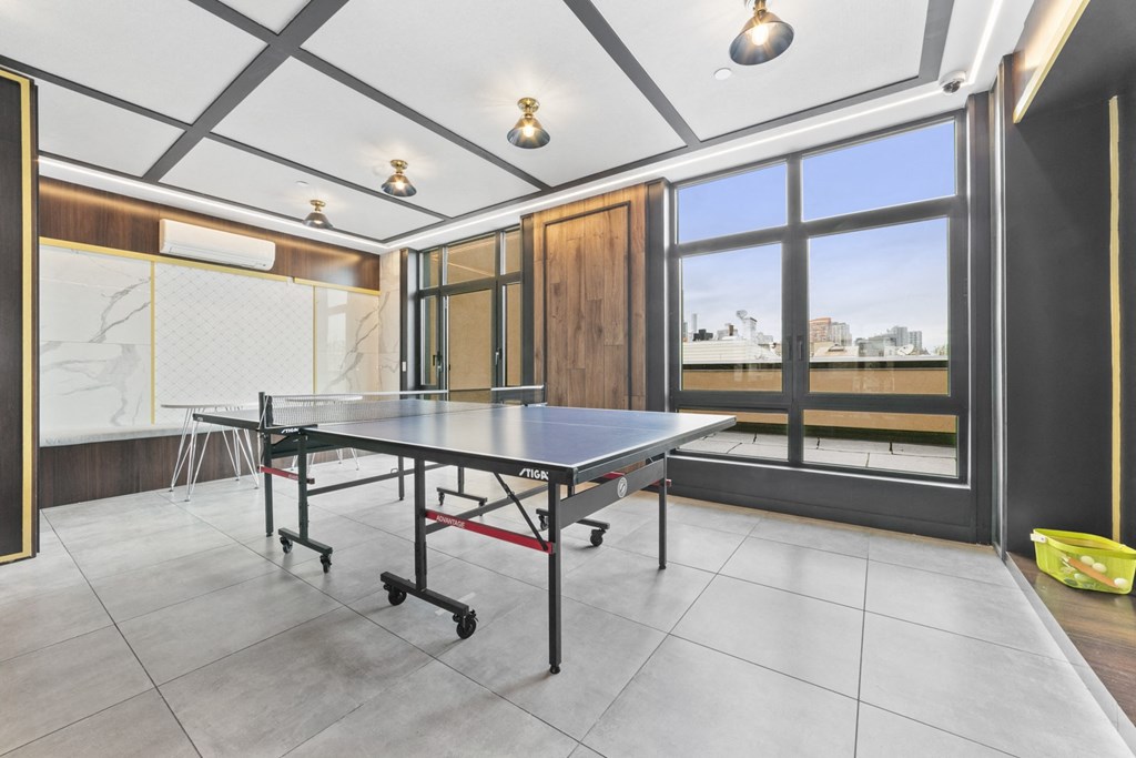 a ping pong table in a game room with a view of the city