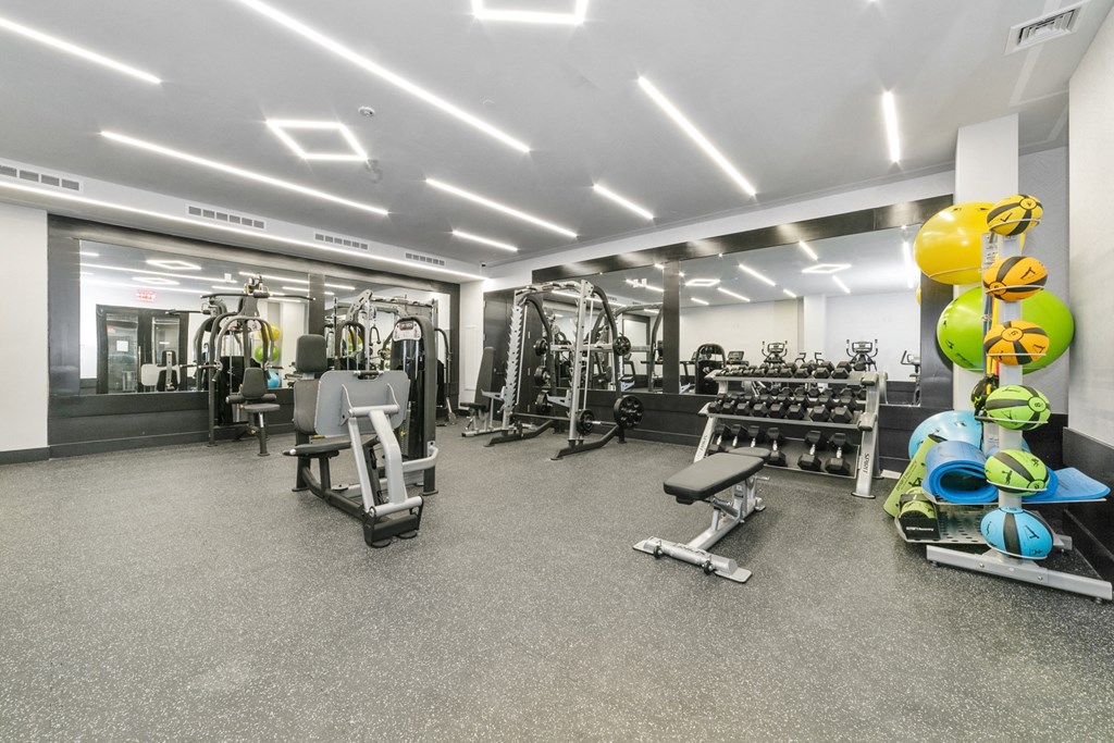 a gym with cardio equipment and weights on the floor