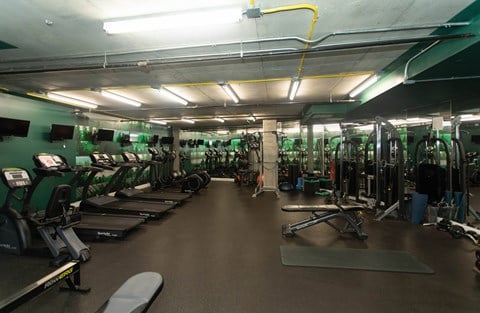 A gym with treadmills, weights, and exercise equipment.